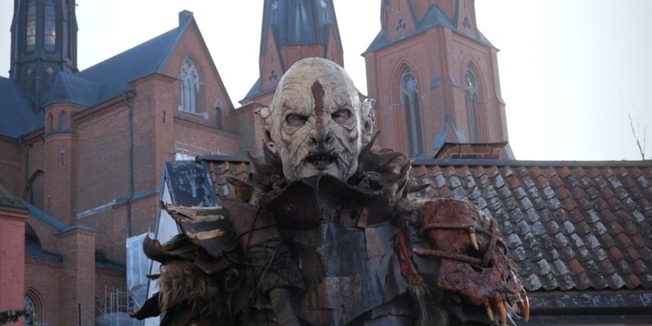 Person som lajvar som orsch framför domkyrkan i uppsala