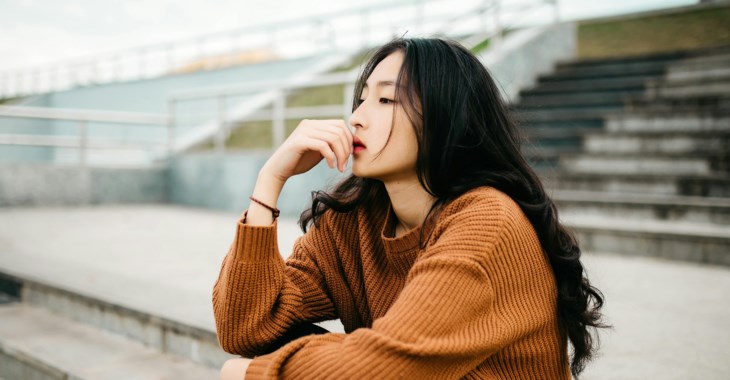 Ung tjej sitter i en trappa utomhus .