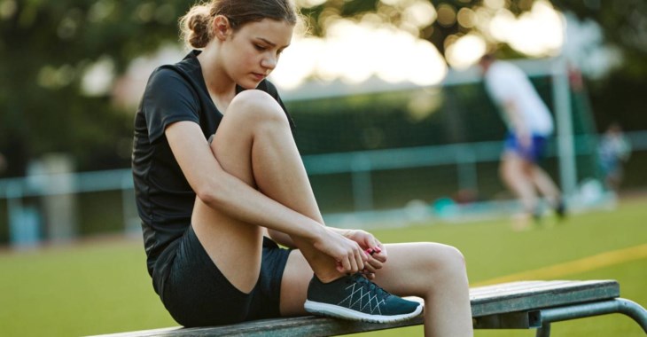 Flicka knyter sin sko idrottsplats.