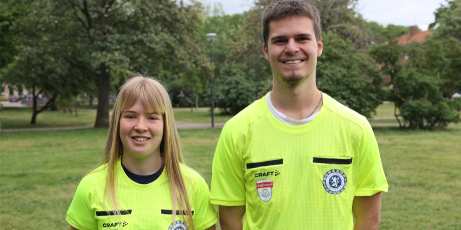 Två unga domare ler mot kameran.