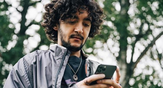 En man som kollar i sin mobil