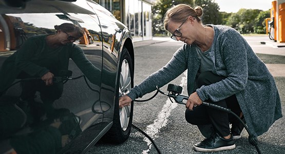 Kvinna mäter lufttryck på sin bil.