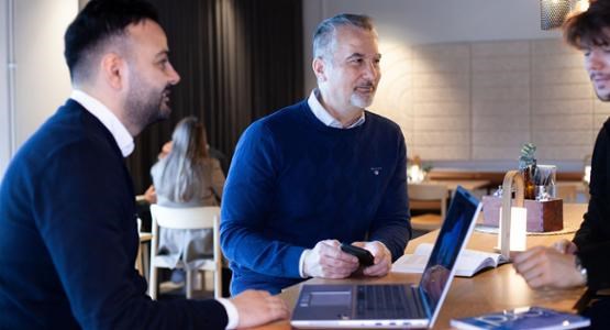 Tre män vid datorn.