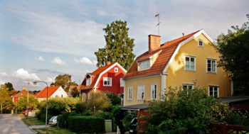 En gul trävilla i ett bostadskvarter