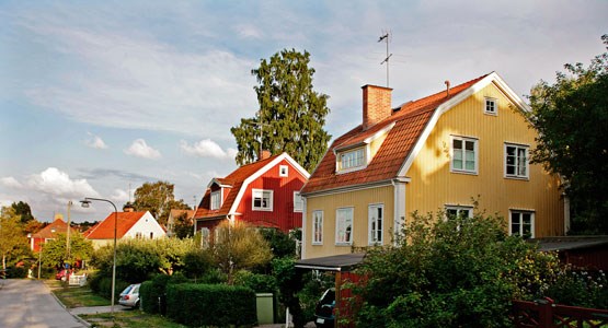 En gul trävilla i ett bostadskvarter