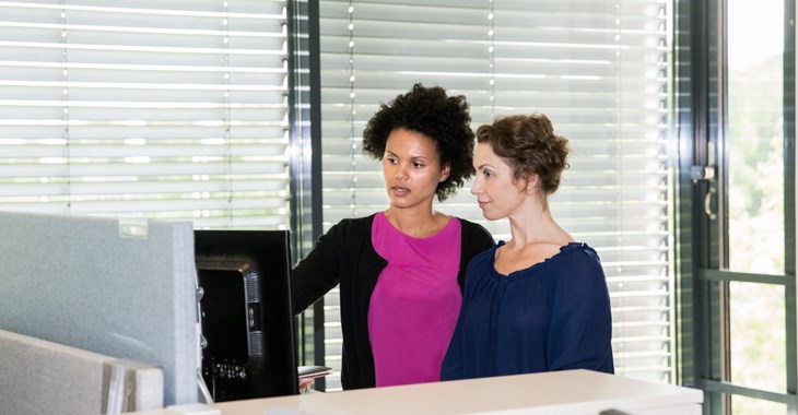 Fotografi av kvinnor vid dator. 