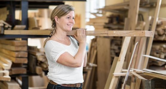 Kvinna bär plankor.