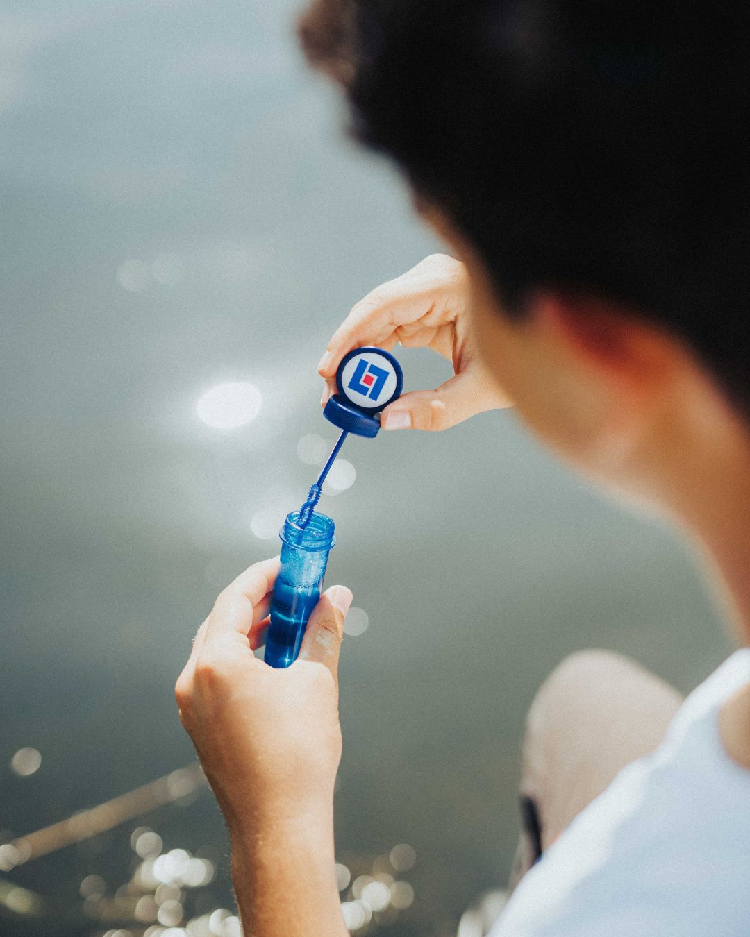 kille blåser såpbubblor vid vatten. Bild. 