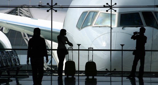 Siluetter tittar på ett flygplan genom ett fönster