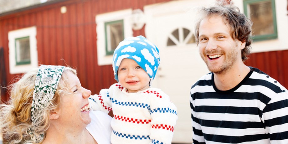 Barnfamilj utanför hus.