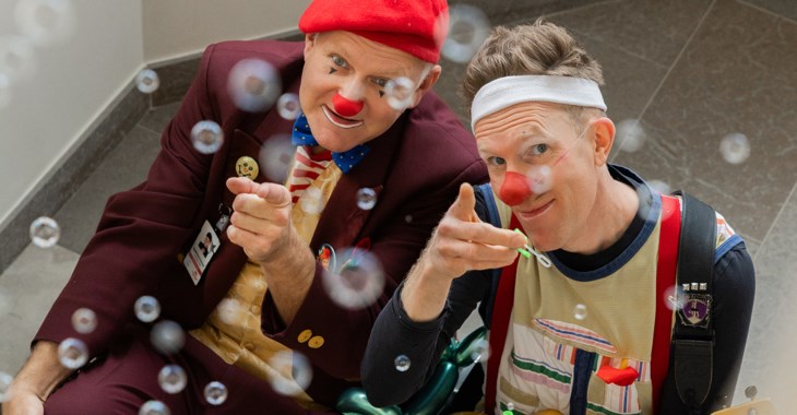 Två clowner som pekar mot kameran och som omges av såpbubblor