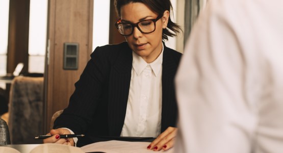 Kvinna funderar när hon läser igenom papper.