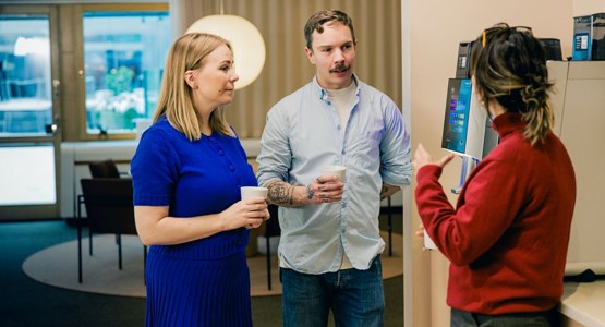 Tre personer står och pratar. 