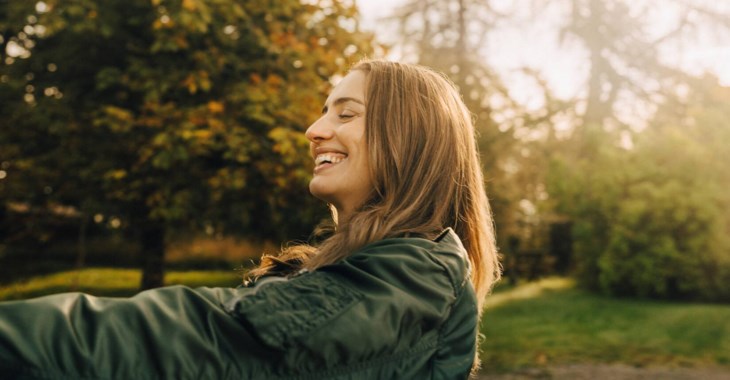 Nöjd kvinna i kvällsljus som tecknat grönt bolån.