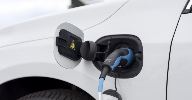 En vit elbil som laddas.