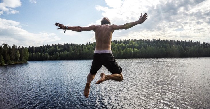 Foto på kille som hoppar i vattnet.