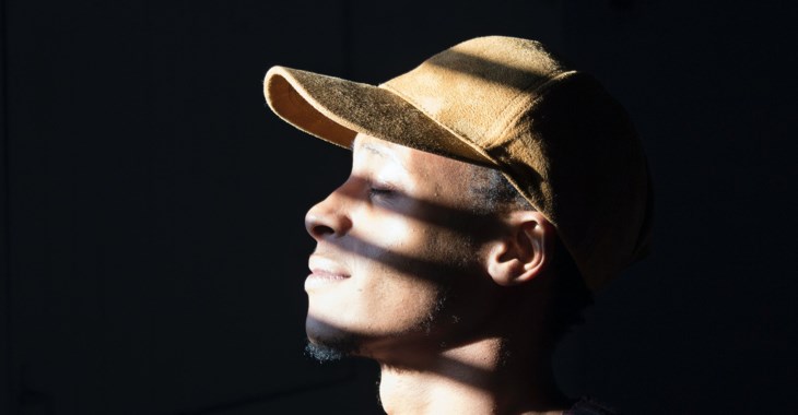 Foto på en man som blundar med ansiktet i solen.