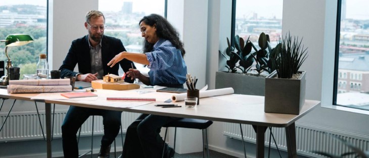 Två kollegor arbetar vid skrivbord