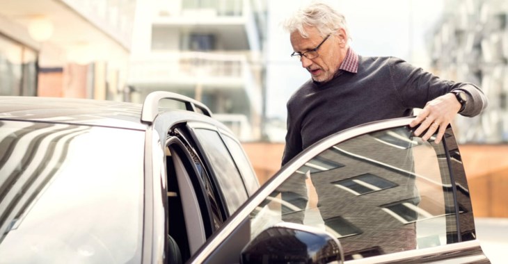 Man kliver in i tjänstebil.