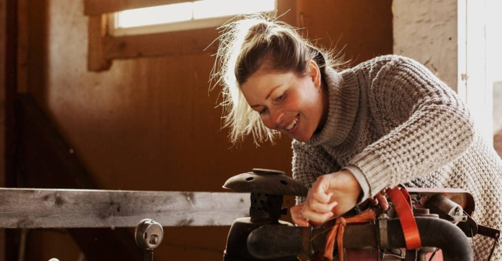Kvinna mekar med maskin i verkstad.
