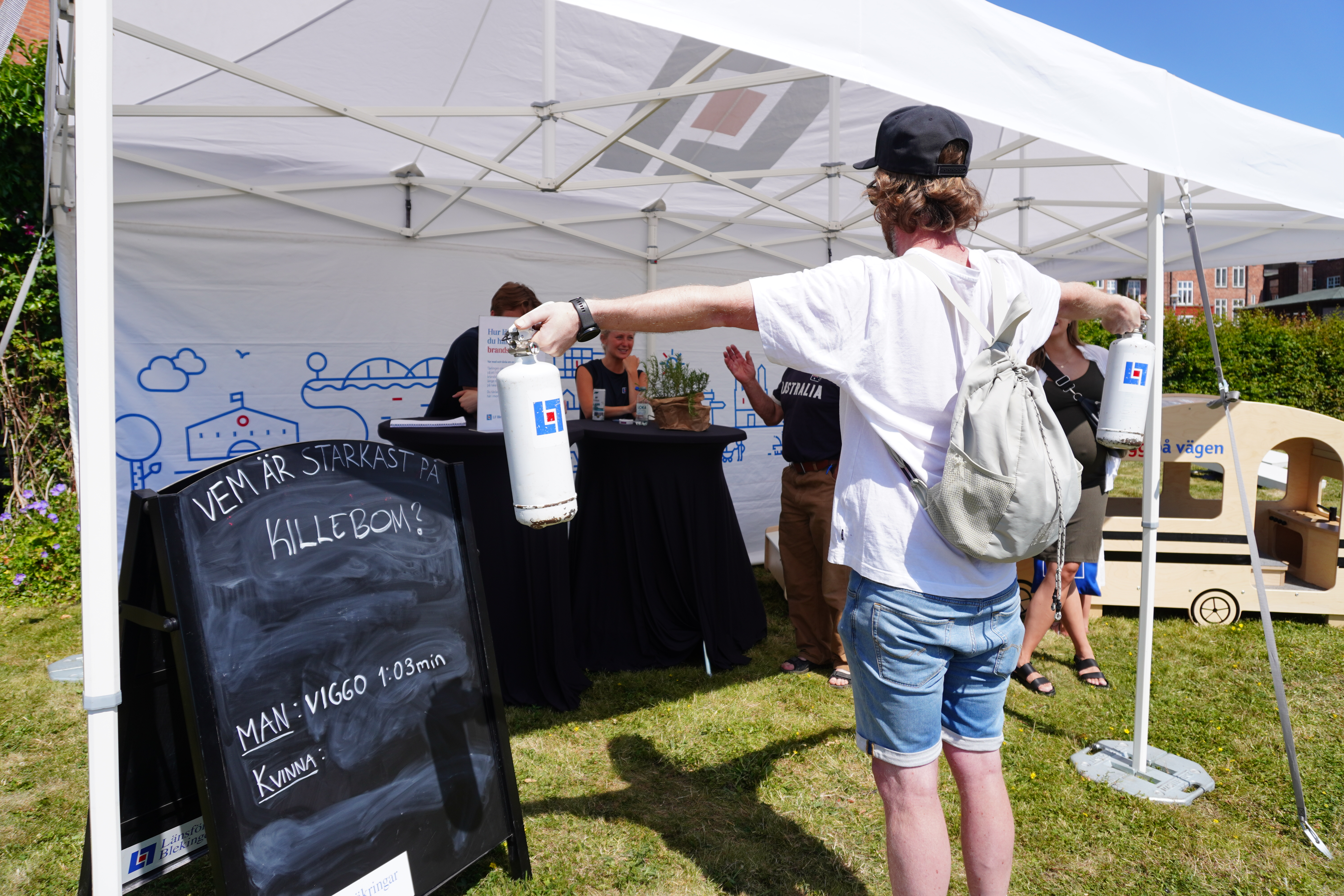man håller i två brandsläckare