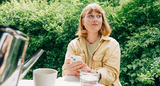 Kvinna med mobil i handen.