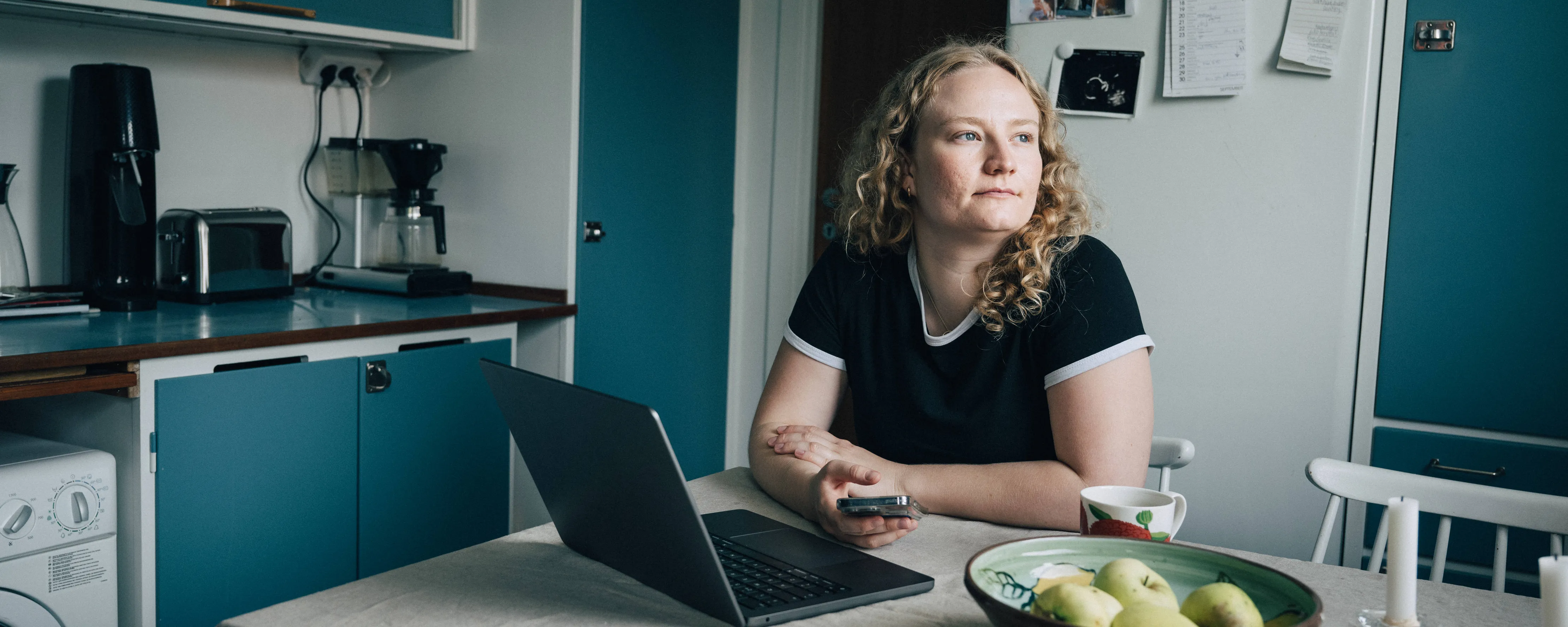 Kvinna kollar sitt sparkonto  och drömmer sig bort.