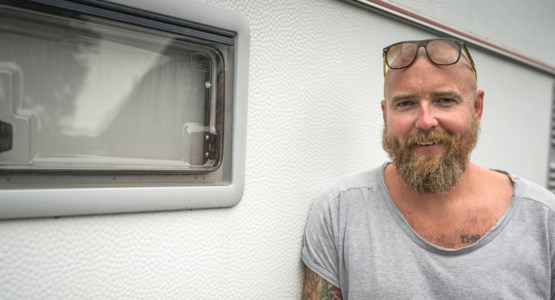 Man står utanför husvagn.