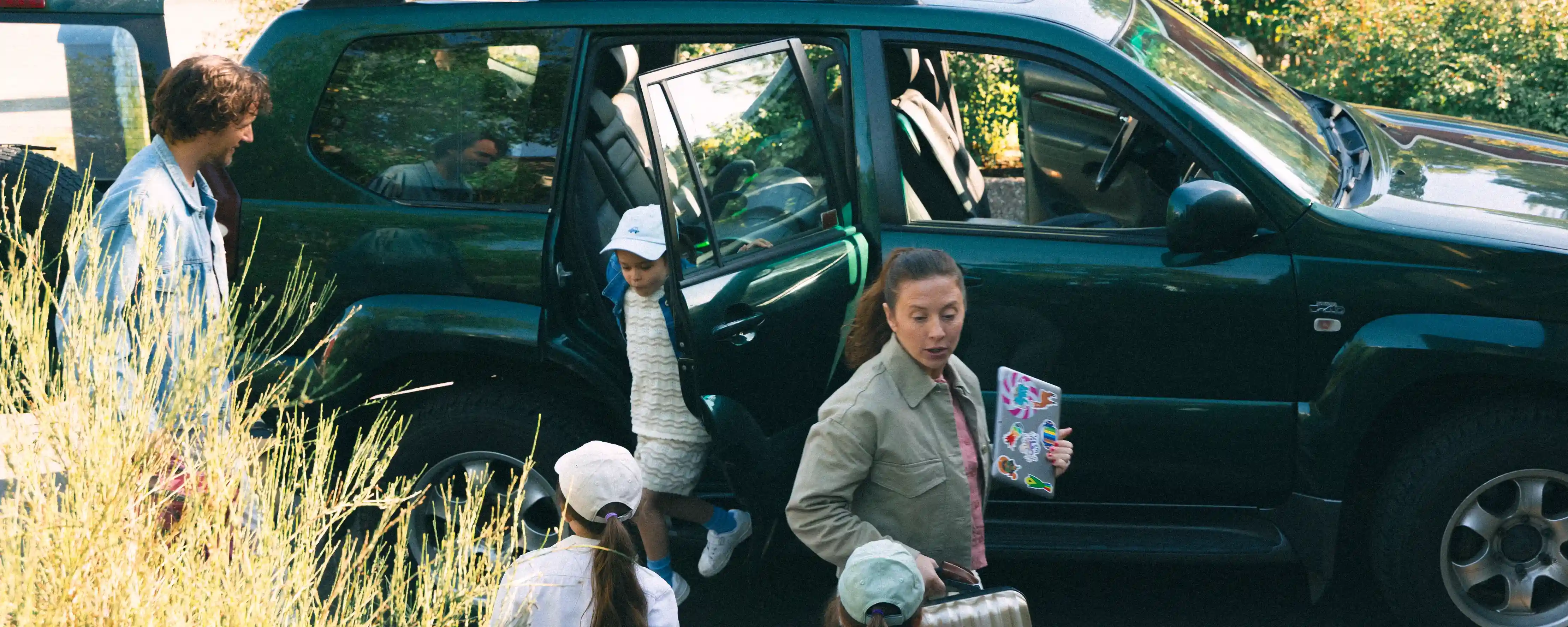 Familj som packar ut resväskor ur bilen.