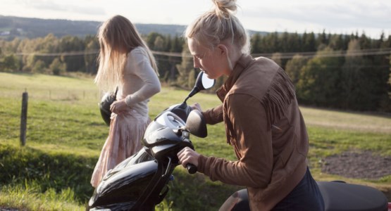 tjejer med moped vid en sommaräng