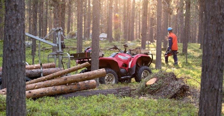 Man i skog brevid fyrhjuling.