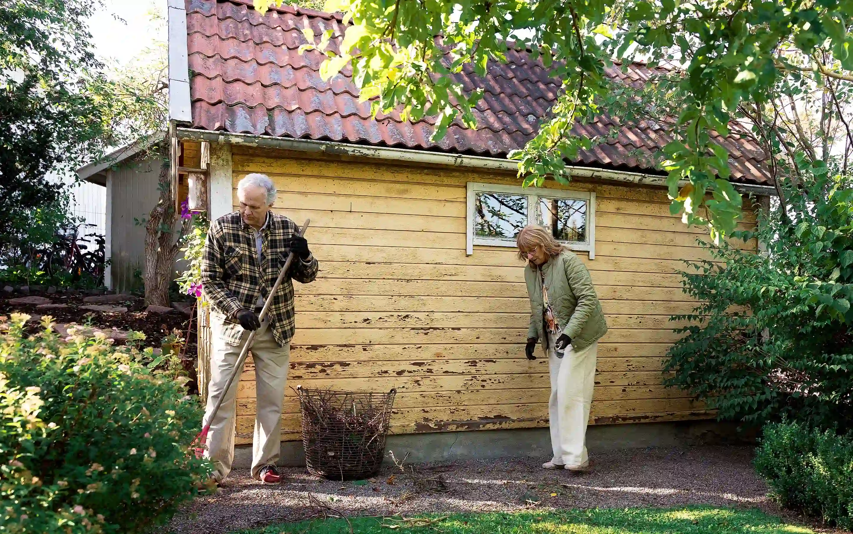 Par som fixar i trädgården vid sitt fritidshus.