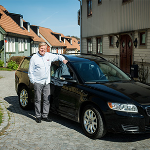 Man som står vid sin bil. Bild. 