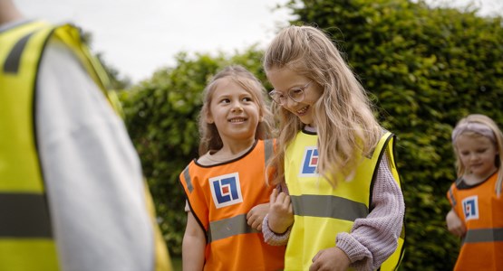 Två förskolebarn i reflexväst.