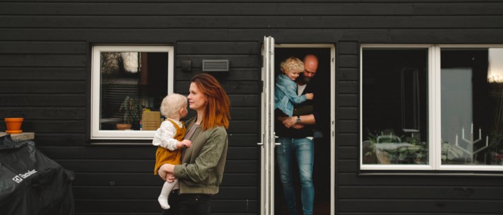En familj med mamma, pappa och två barn är på väg ut från sitt hus.