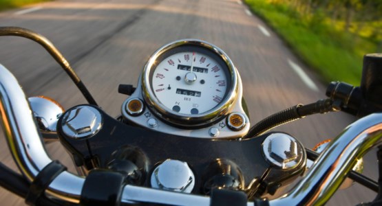 Instrumentpanelen på en motorcykel som åker längs en landsväg.