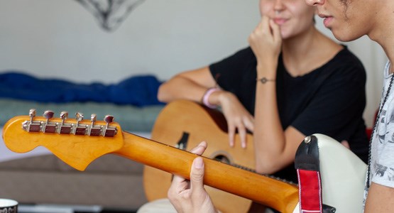 Ungdomar spelar på elgitarr