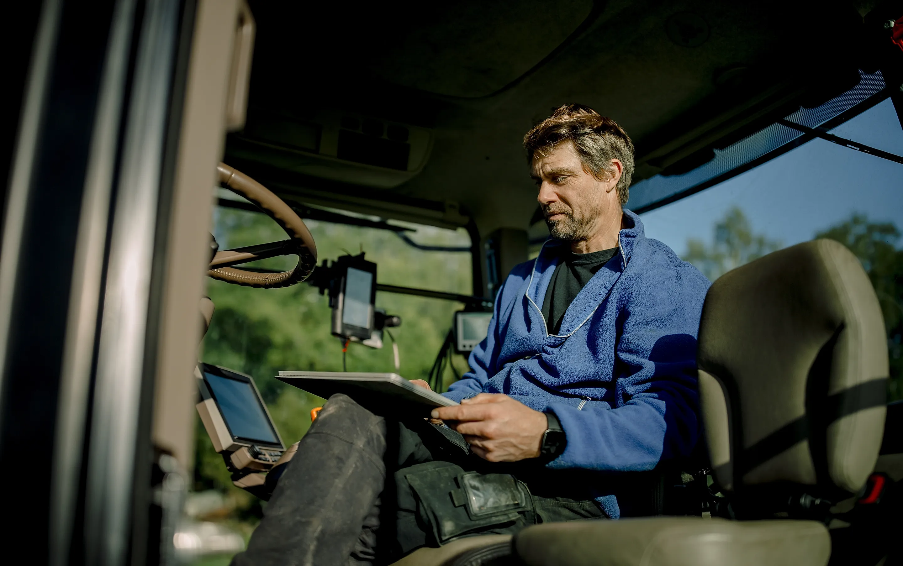 Lantbrukare sitter i en traktor.