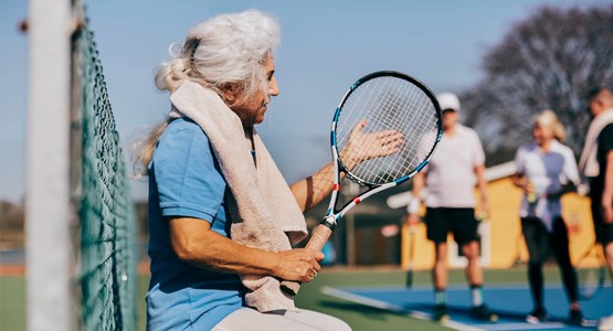 Äldre kvinna med tennisracket
