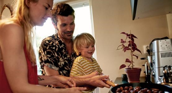 Familj i köket steker köttbullar.