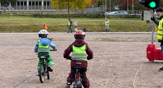 Barn på cykel vid ett trafiljus