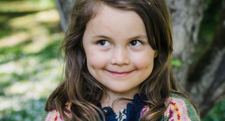 En flicka ler stort och ser busig ut.