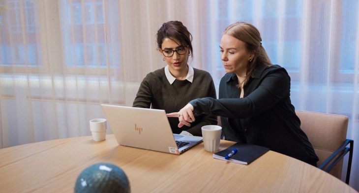 Kvinnor sitter med en laptop