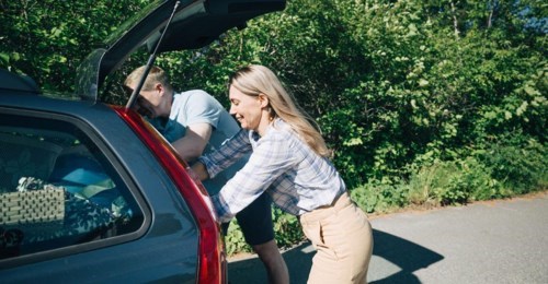 Man och kvinna öppnar baklucka