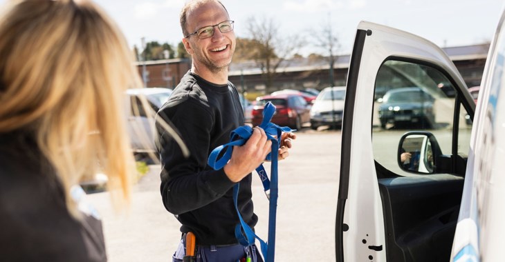 Kvinna sitter och arbetar på laptop i ljuset från ett fönster.