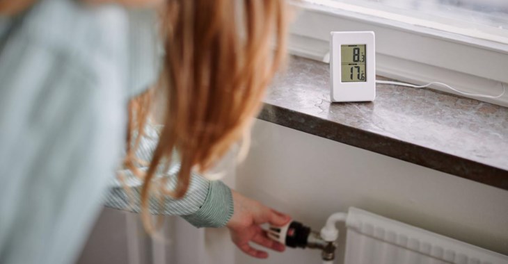 Kvinna sänker värmen på elementet.