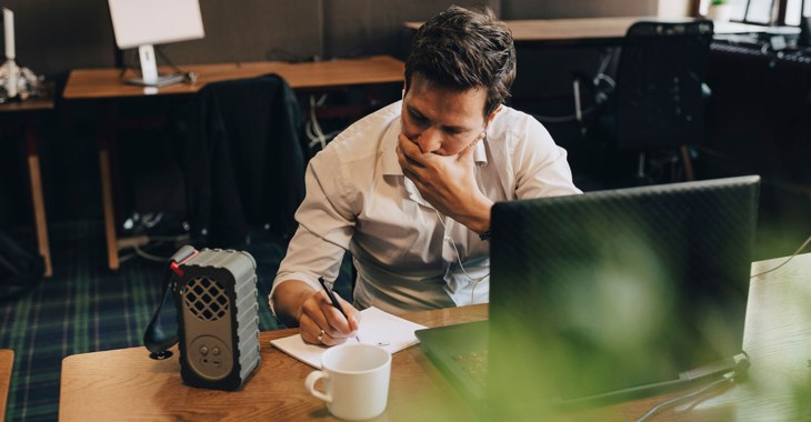 Man vid dator i kontorsmiljö.