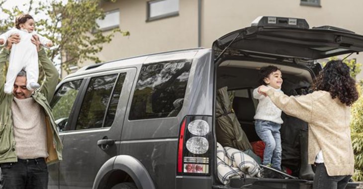 Barnfamilj som packar bilen inför resa