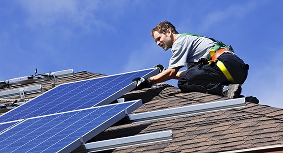 Man som installerar solceller på tak