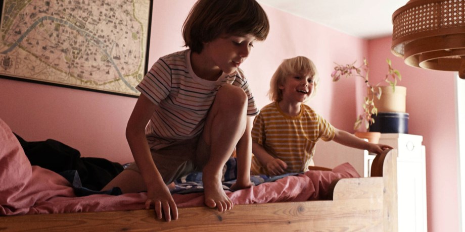 Två barn leker i en våningsäng